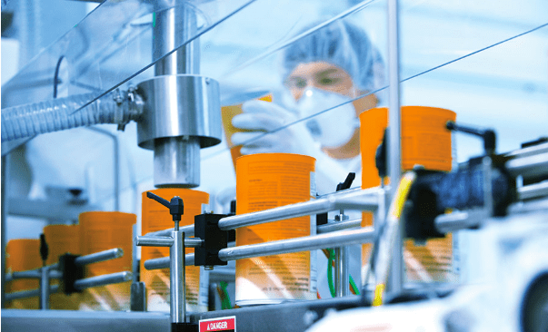 co-packers con múltiples empleados empaquetando alimentos en cajas de cartón sobre cintas transportadoras.